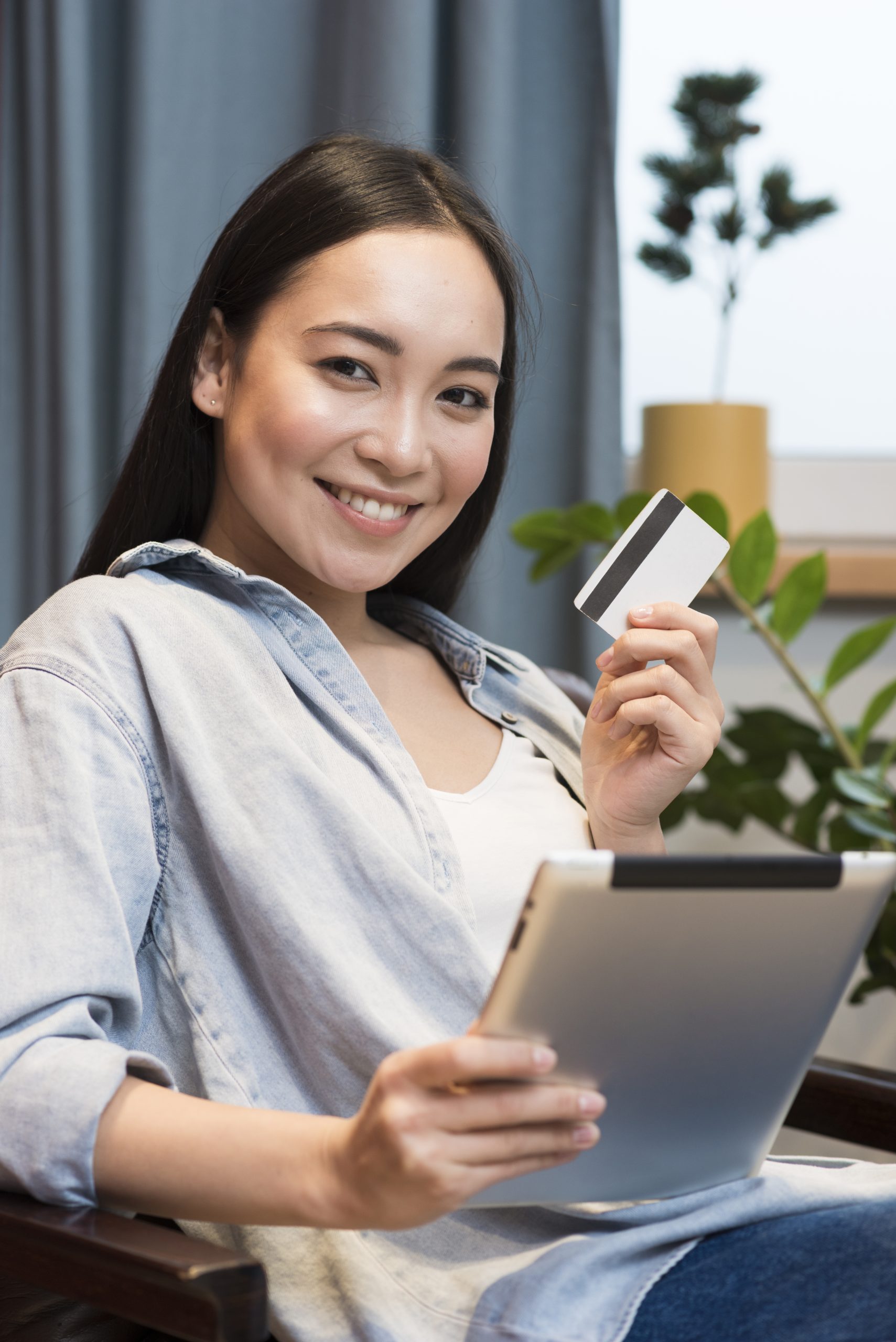 smiley-woman-posing-while-holding-tablet-credit-card